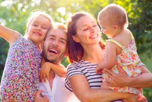 Jeune famille - un père, une mère et deux enfants qui semblent heureux et satisfaits